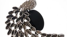 Brosa metalica argintie cu design de paun si pietre negre, simbol al intelepciunii